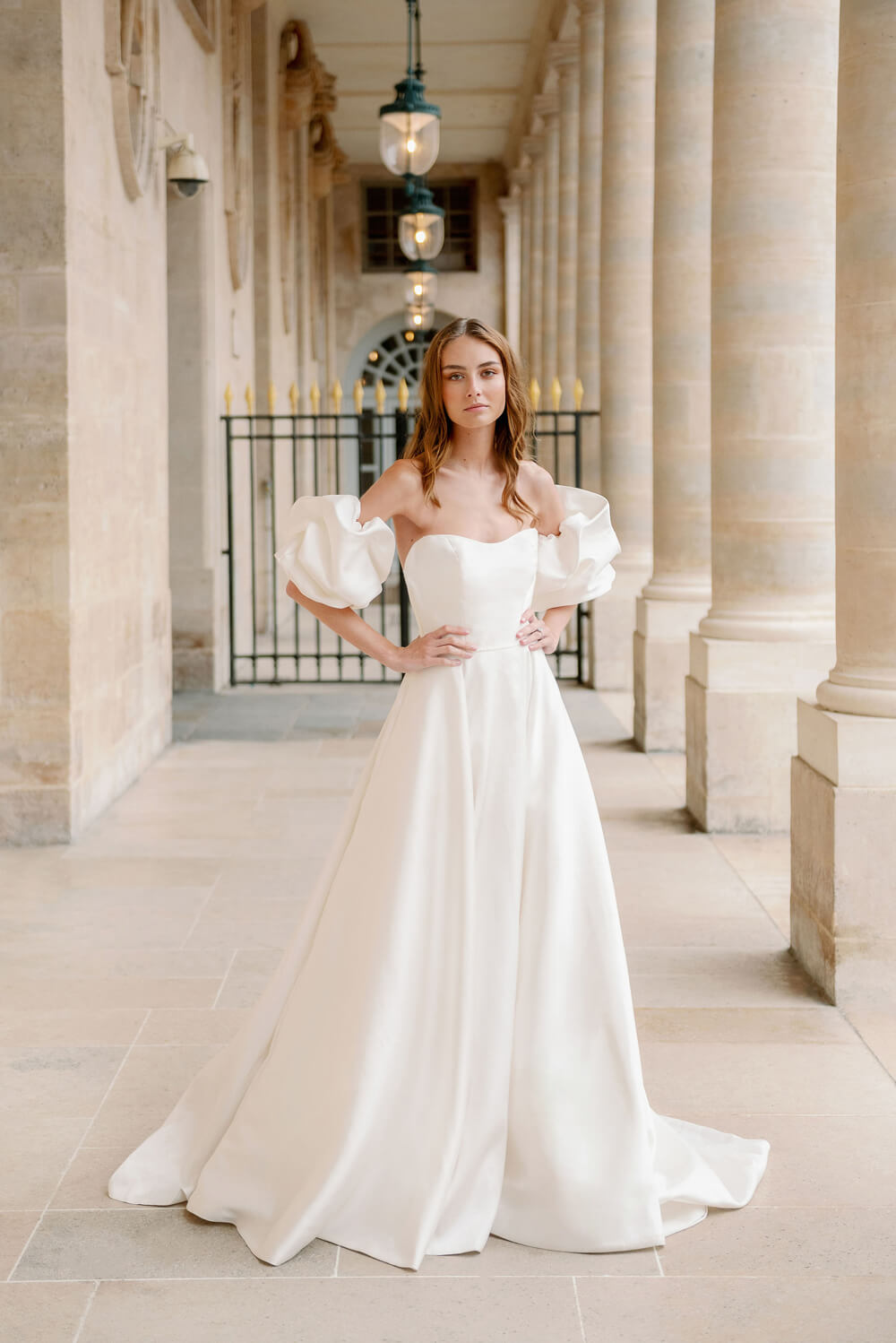 Woman wearing Monique Lhuillier Fall 2023 Bliss white strapless sweetheart BL23201 ballgown with tufted sleeves