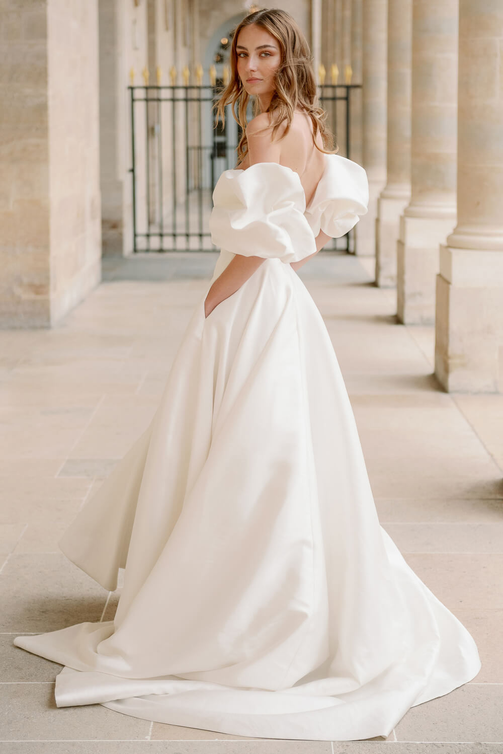 Woman wearing Monique Lhuillier Fall 2023 Bliss white strapless sweetheart BL23201 ballgown with tufted sleeves