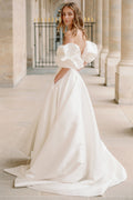 Woman wearing Monique Lhuillier Fall 2023 Bliss white strapless sweetheart BL23201 ballgown with tufted sleeves
