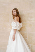 Woman wearing Monique Lhuillier Fall 2023 Bliss white strapless sweetheart BL23201 ballgown with tufted sleeves