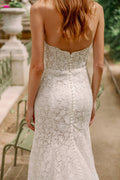 Woman wearing Monique Lhuillier Fall 2023 Bliss white lace strapless sweetheart fitted BL23202 gown with long train