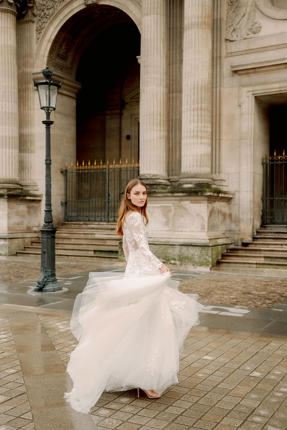 Woman wearing Monique Lhuillier Fall 2023 Bliss long sleeve v-neck white embroidered tulle a-line BL23203 gown