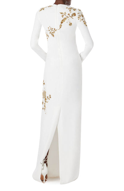 Monique Lhuillier silk white jewel neck, long sleeve column gown with gold embroidery.