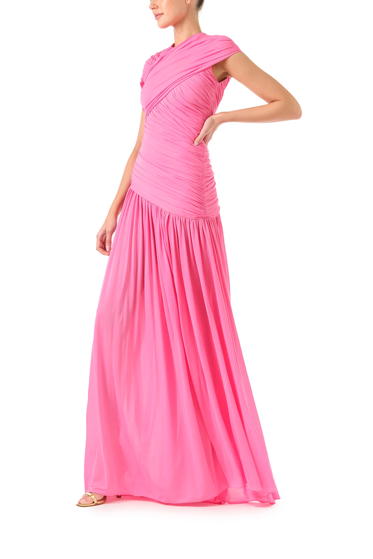 Monique Lhuillier Fall 2024 draped, asymmetric gown with drop waist, cap sleeves and front leg slit in pink crepe jersey fabric - left side.