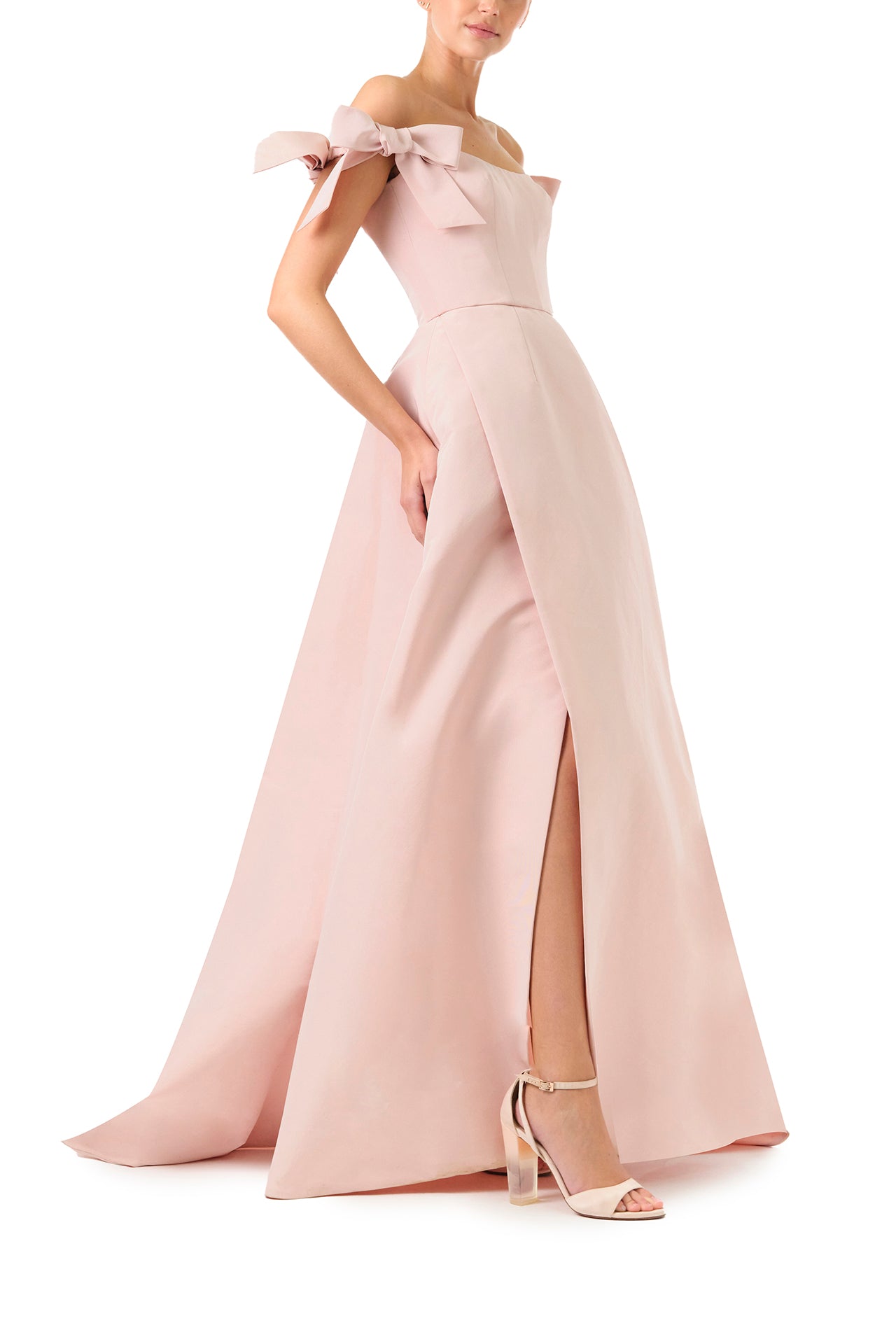 Monique Lhuillier Fall 2024 off the shoulder bow sleeve gown in pale blush faille with full skirt and high leg slit - side with slit.