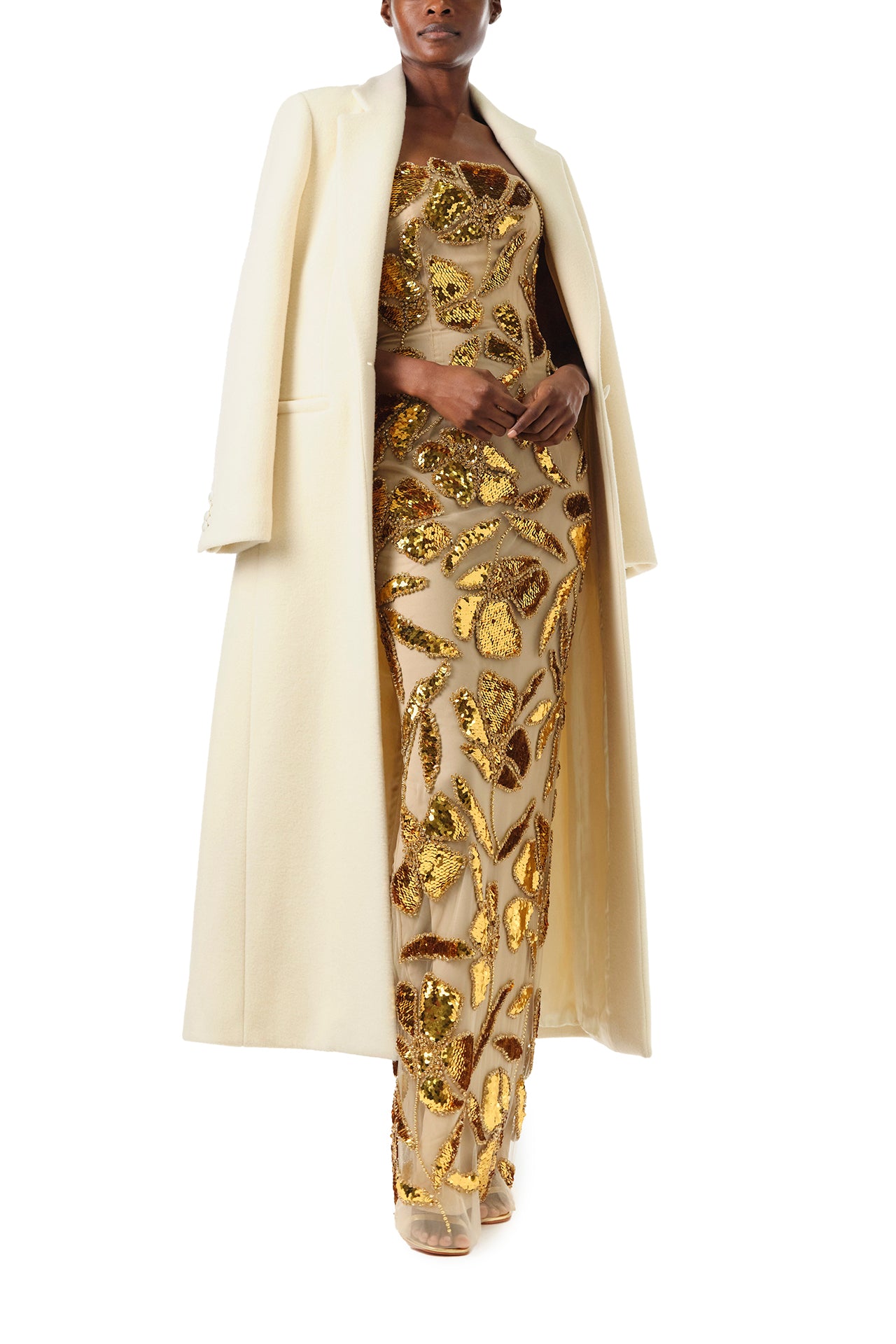 Monique Lhuillier Fall 2024 strapless column gown in gold embroidered tulle - front with coat.