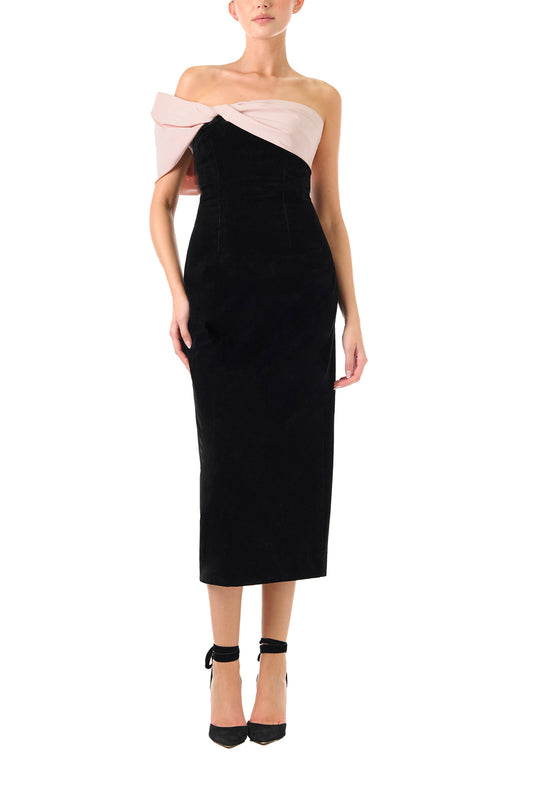 Monique Lhuillier Fall 2024 black velvet off the shoulder sheath dress with pale blush draped, asymmetric twist detail at neckline - front.