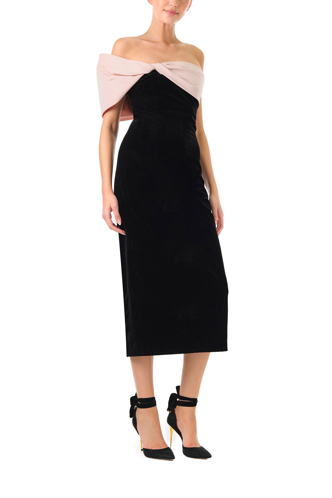 Monique Lhuillier Fall 2024 black velvet off the shoulder sheath dress with pale blush draped, asymmetric twist detail at neckline - right side.