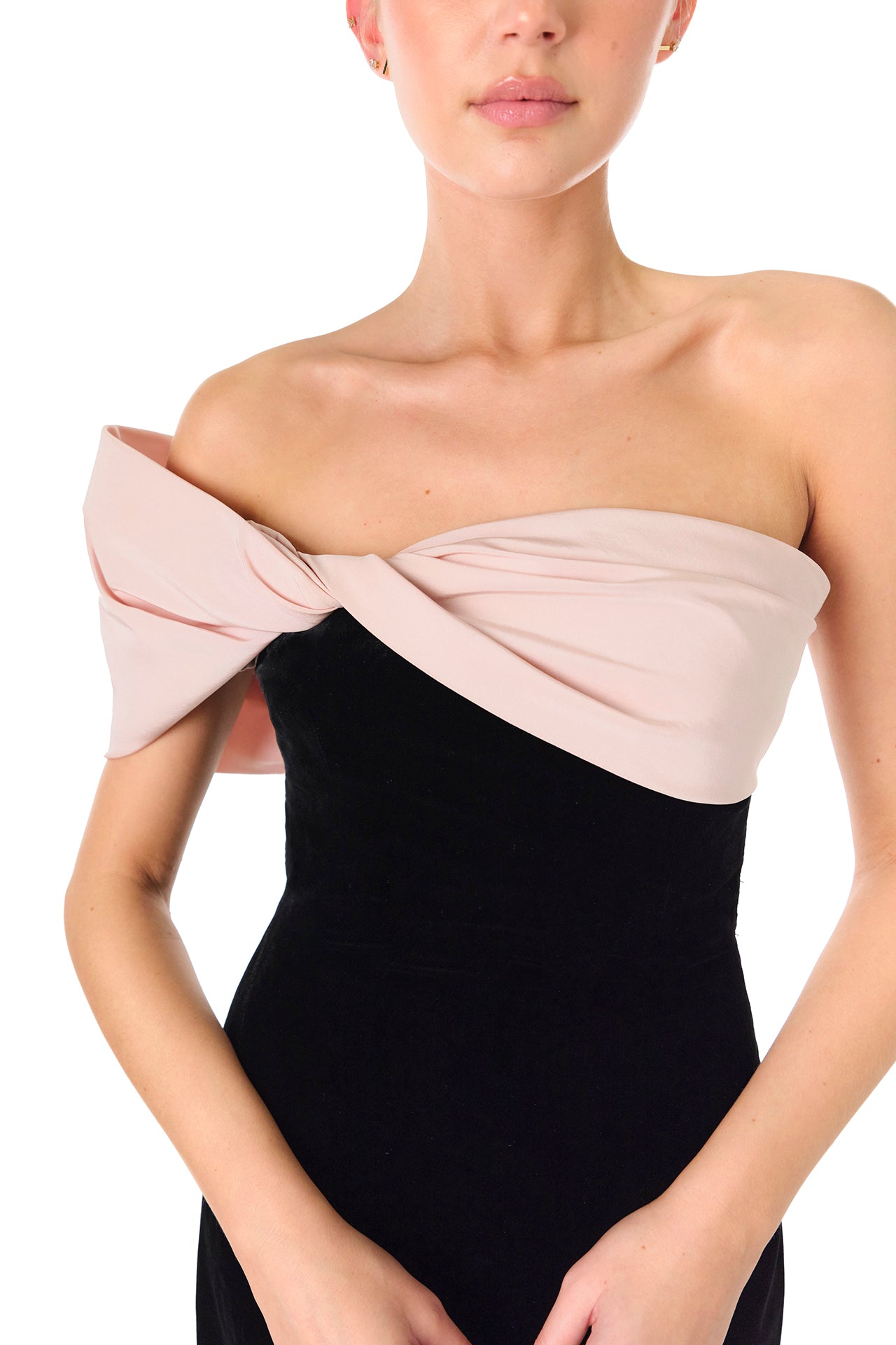 Monique Lhuillier Fall 2024 black velvet off the shoulder sheath dress with pale blush draped, asymmetric twist detail at neckline - neckline detail.