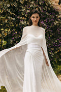Woman wearing white sequin strapless Monique Lhuillier Spring 2023 Pearla draped column gown with white chiffon Pearla cape