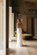Woman wearing ivory silk charmeuse Monique Lhuillier Spring 2023 sheath spaghetti strap open back Viola gown