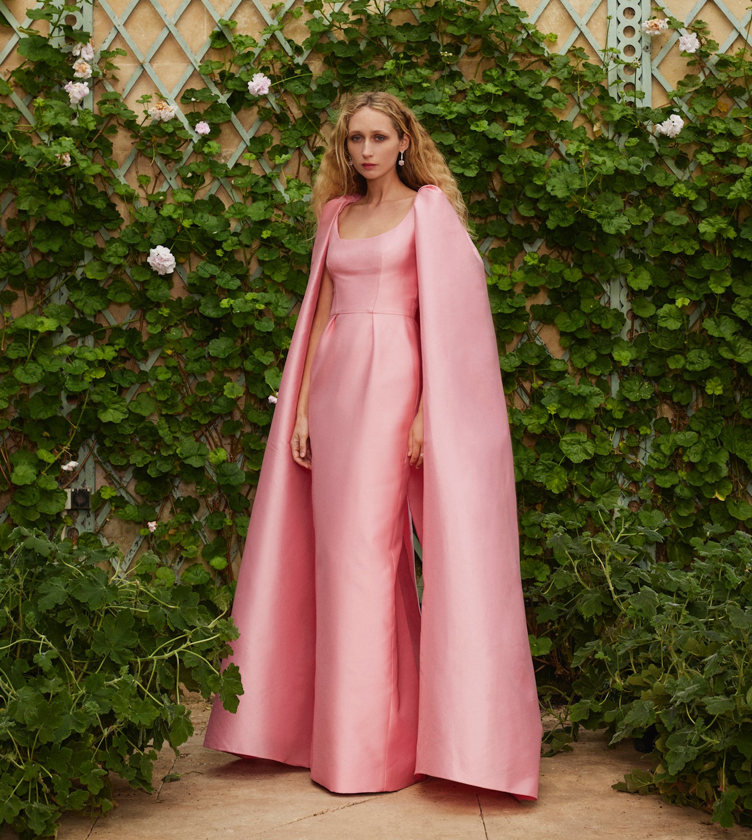Monique Lhuillier Fall 2024 dahlia pink mikado column gown with scoop neck and attached cape.