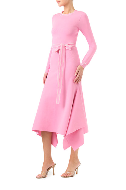 Monique Lhuillier Fall 2024 pink knit long sleeve dress with handkerchief hem and self-tie belt - left side.