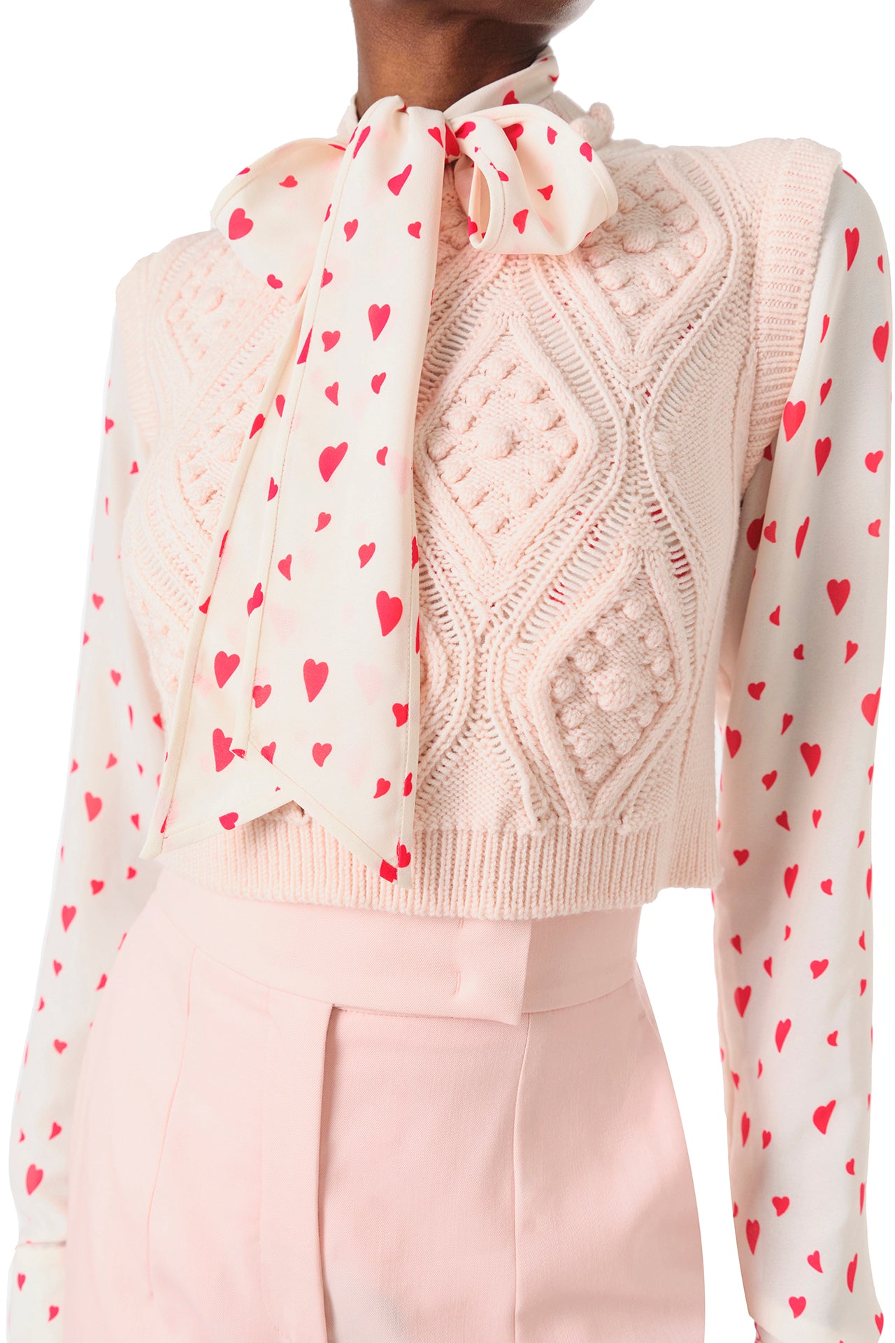 Monique Lhuillier Fall 2024 long sleeve, bow tie blouse in Heart Printed Georgette - front under cable knit sweater.