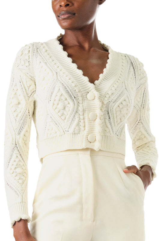 Monique Lhuillier Fall 2024 long sleeve, cropped bobble cardigan in Creme wool cable knit - front crop.