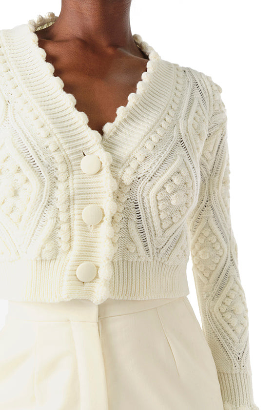 Monique Lhuillier Fall 2024 long sleeve, cropped bobble cardigan in Creme wool cable knit - fabric detail.