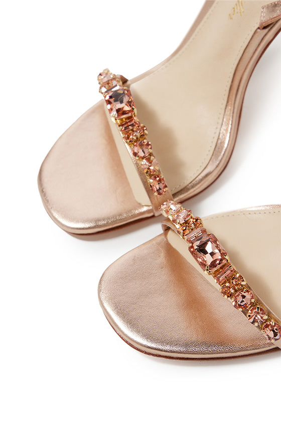 Monique Lhuillier Kirby heel in rose gold metallic leather with rhinestone toe strap and slingback.