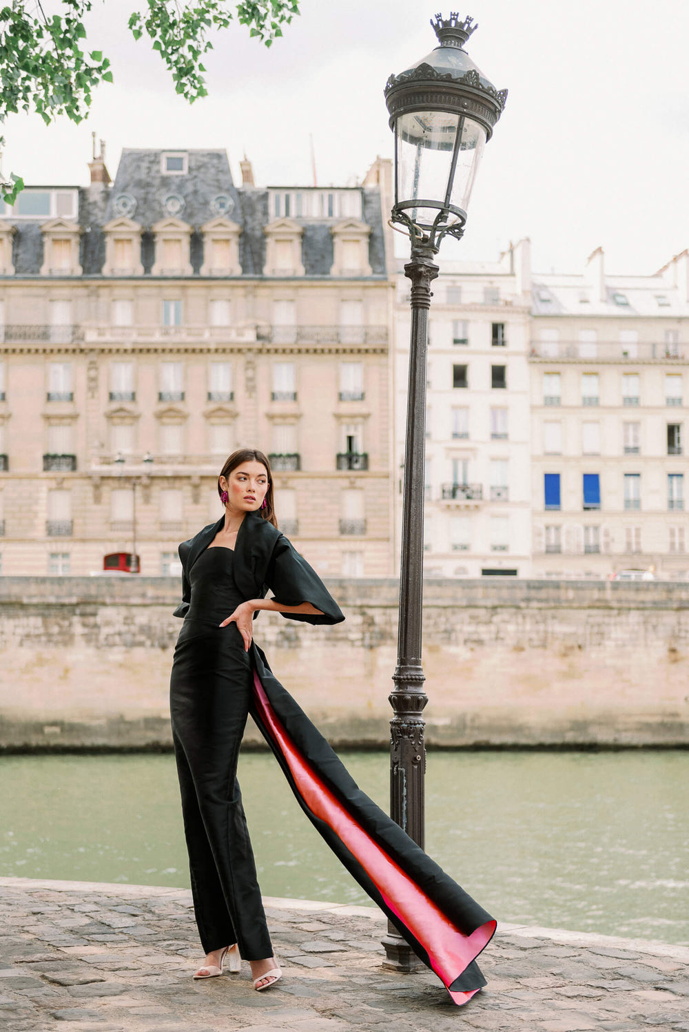 Monique Lhuillier Spring 2024 draped cocoon evening jacket in black faille shown with the strapless column gown in black and pink.