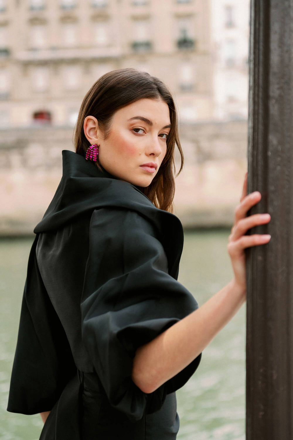 Monique Lhuillier Spring 2024 draped cocoon evening jacket in black faille shown with the strapless column gown in black and pink.