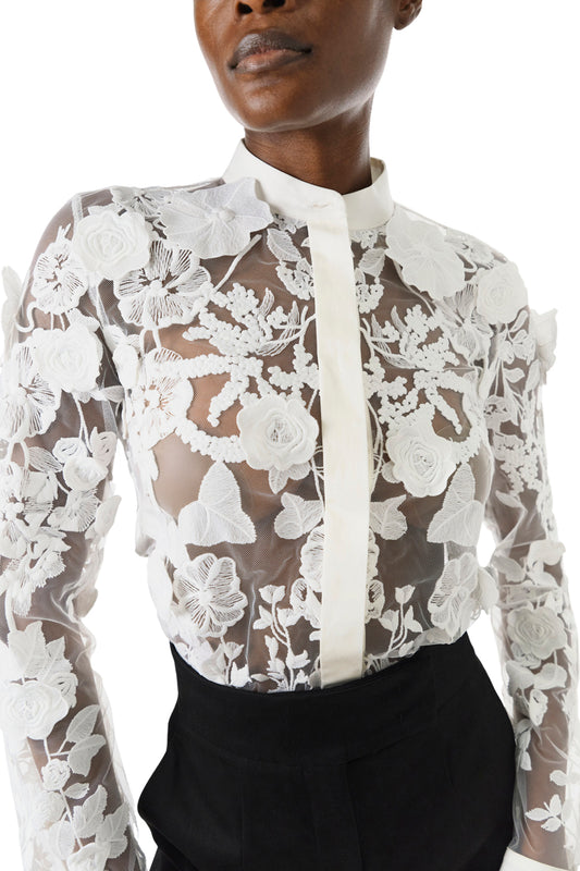 Monique Lhuillier Fall 2024 button front sheer lace blouse in Silk White 3D lace - front crop.