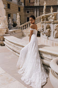 Woman wearing Monique Lhuillier Spring 2023 Bliss white fitted lace off-the-shoulder BL23108 gown