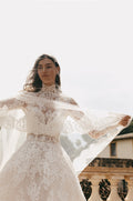 Woman wearing ivory lace Monique Lhuillier Spring 2023 Angelina ballgown with lace Angelina jacket and lace-trimmed Angelina veil