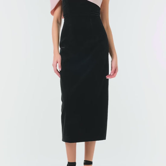 Monique Lhuillier Fall 2024 black velvet off the shoulder sheath dress with pale blush draped, asymmetric twist detail at neckline - video.