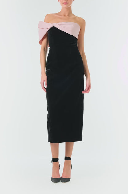 Monique Lhuillier Fall 2024 black velvet off the shoulder sheath dress with pale blush draped, asymmetric twist detail at neckline - video.