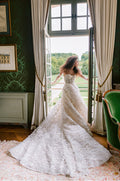 Woman wearing Monique Lhuillier Fall 2023 3-d floral embroidered Versailles ivory ballgown with matching embroidered opera length gloves